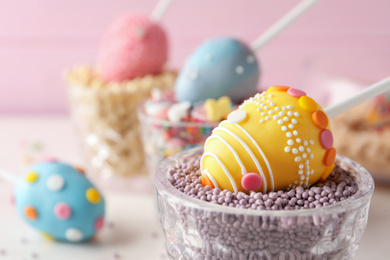 Photo of Egg shaped cake pop on table, closeup with space for text. Easter celebration