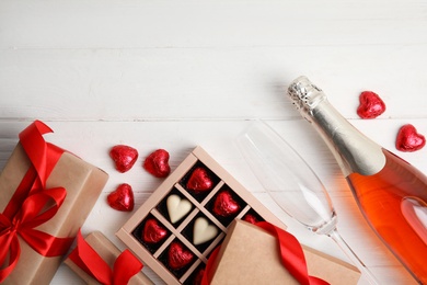 Flat lay composition with heart shaped chocolate candies on white wooden table, space for text. Happy Valentine's day