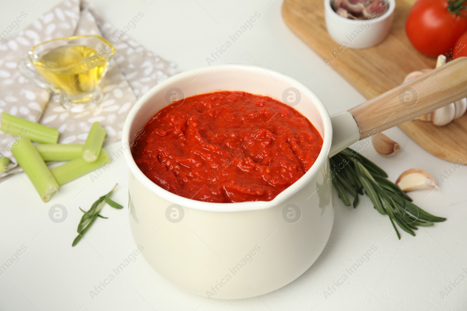 Photo of Delicious tomato sauce in pan on white table