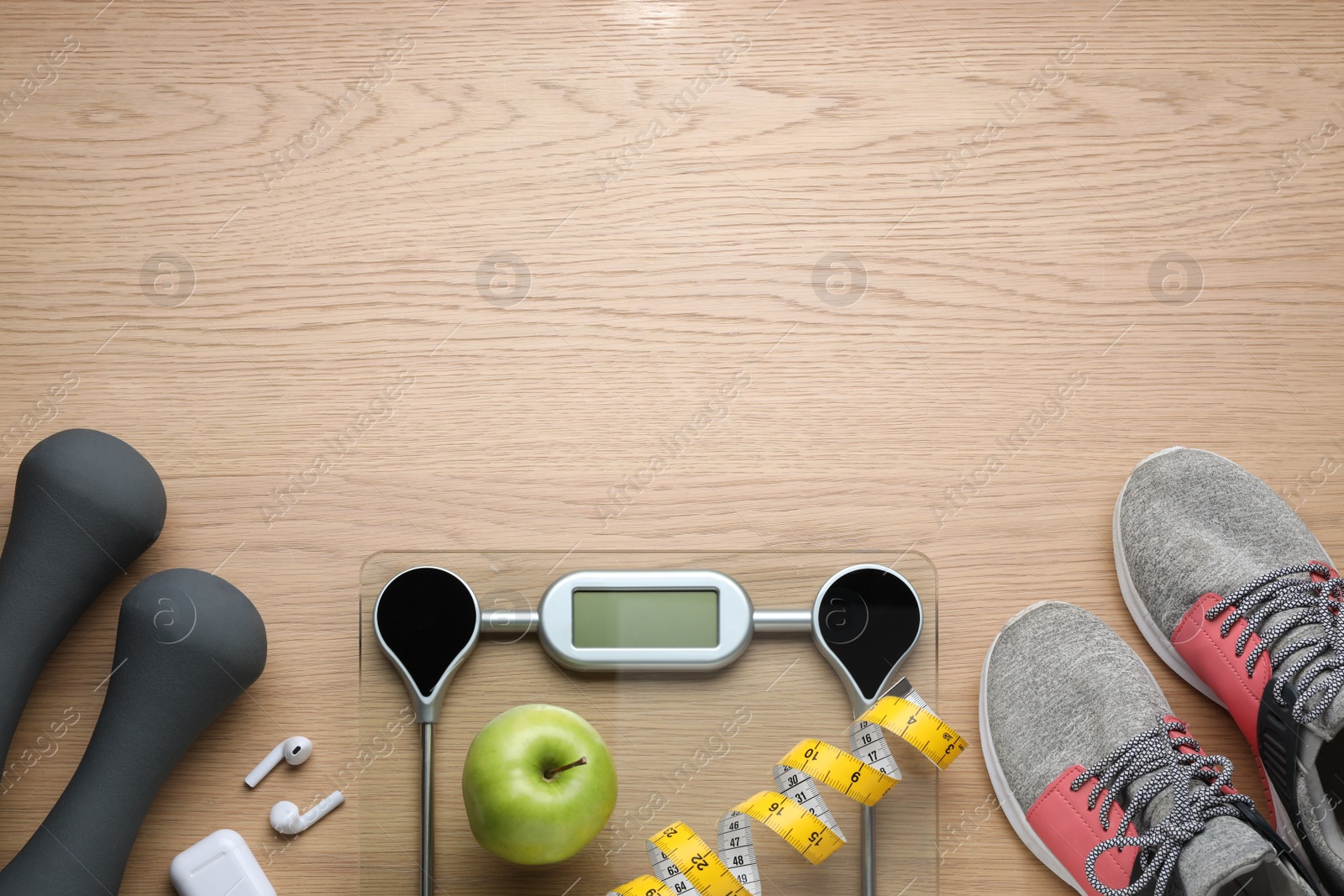 Photo of Flat lay composition with electronic scales and measuring tape on wooden background, space for text