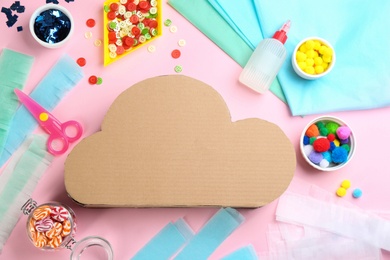 Photo of Flat lay composition with cardboard cloud on pink background. Pinata diy