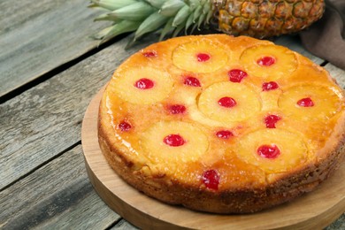Photo of Tasty pineapple cake with cherries on wooden table, closeup. Space for text