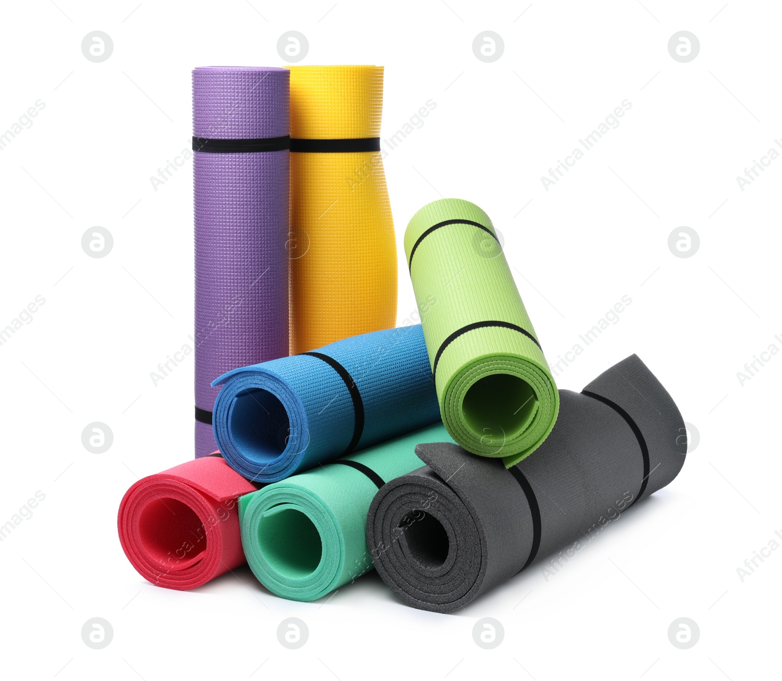 Photo of Colorful rolled camping or exercise mats on white background