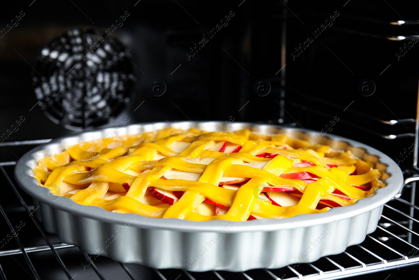 Photo of Traditional English apple pie on shelf of oven, closeup