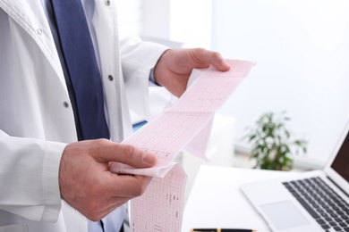 Photo of Doctor examining cardiogram in medical clinic, closeup