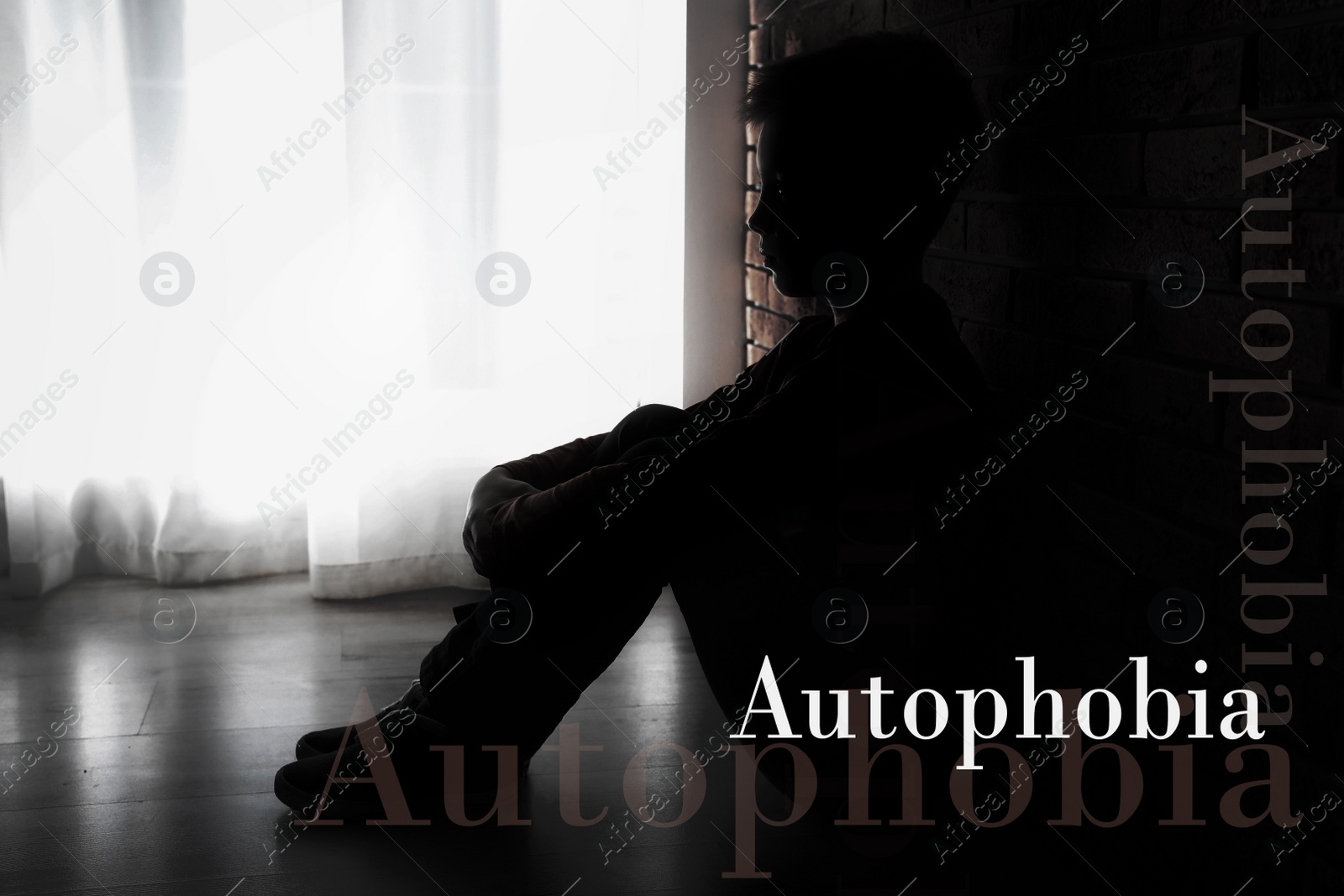 Image of Depressed little boy sitting alone near brick wall. Autophobia - fear of isolation