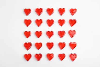 Photo of Sweet heart shaped jelly candies on white background, flat lay