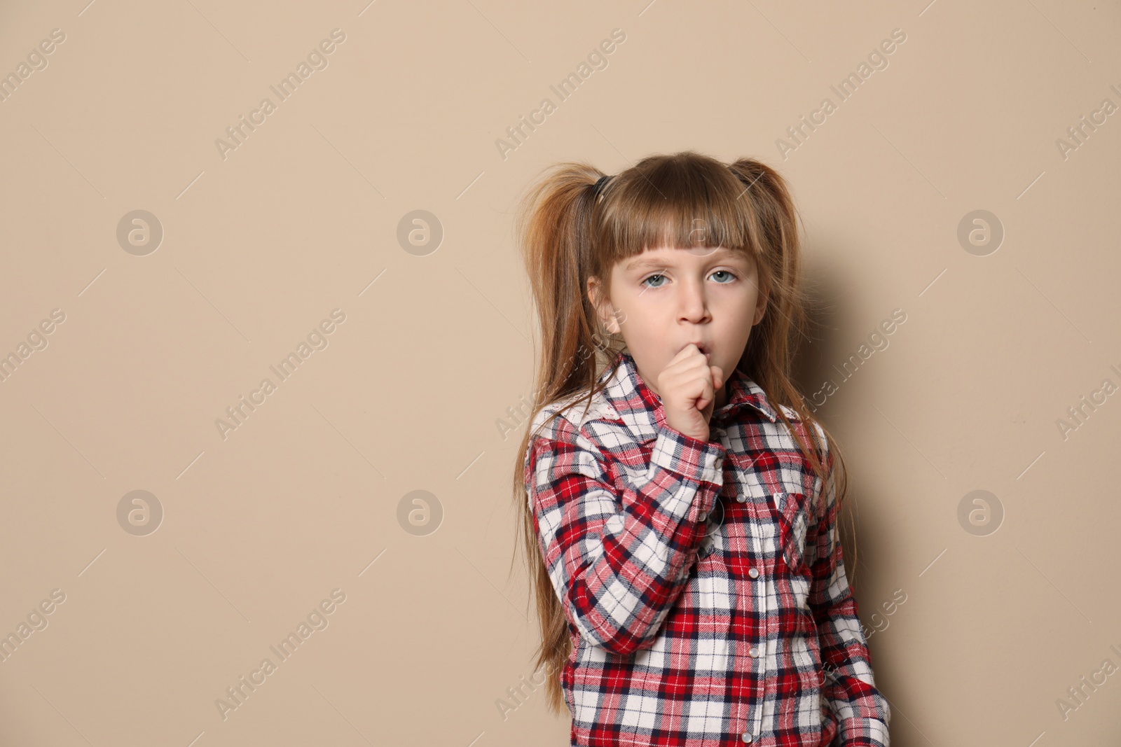 Photo of Cute little girl coughing against color background. Space for text