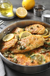 Photo of Delicious chicken piccata on grey table, closeup