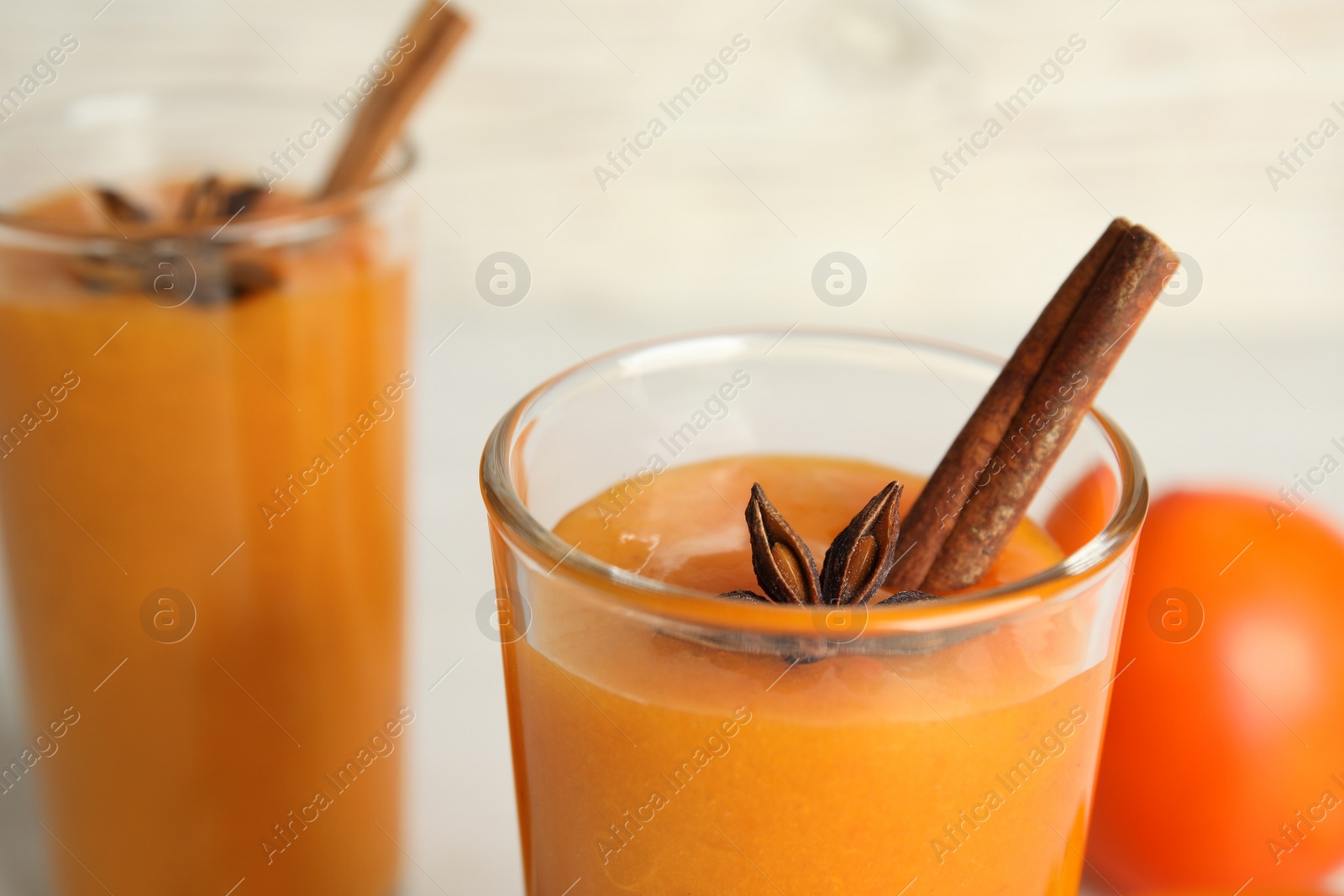 Photo of Tasty persimmon smoothie with anise and cinnamon, closeup