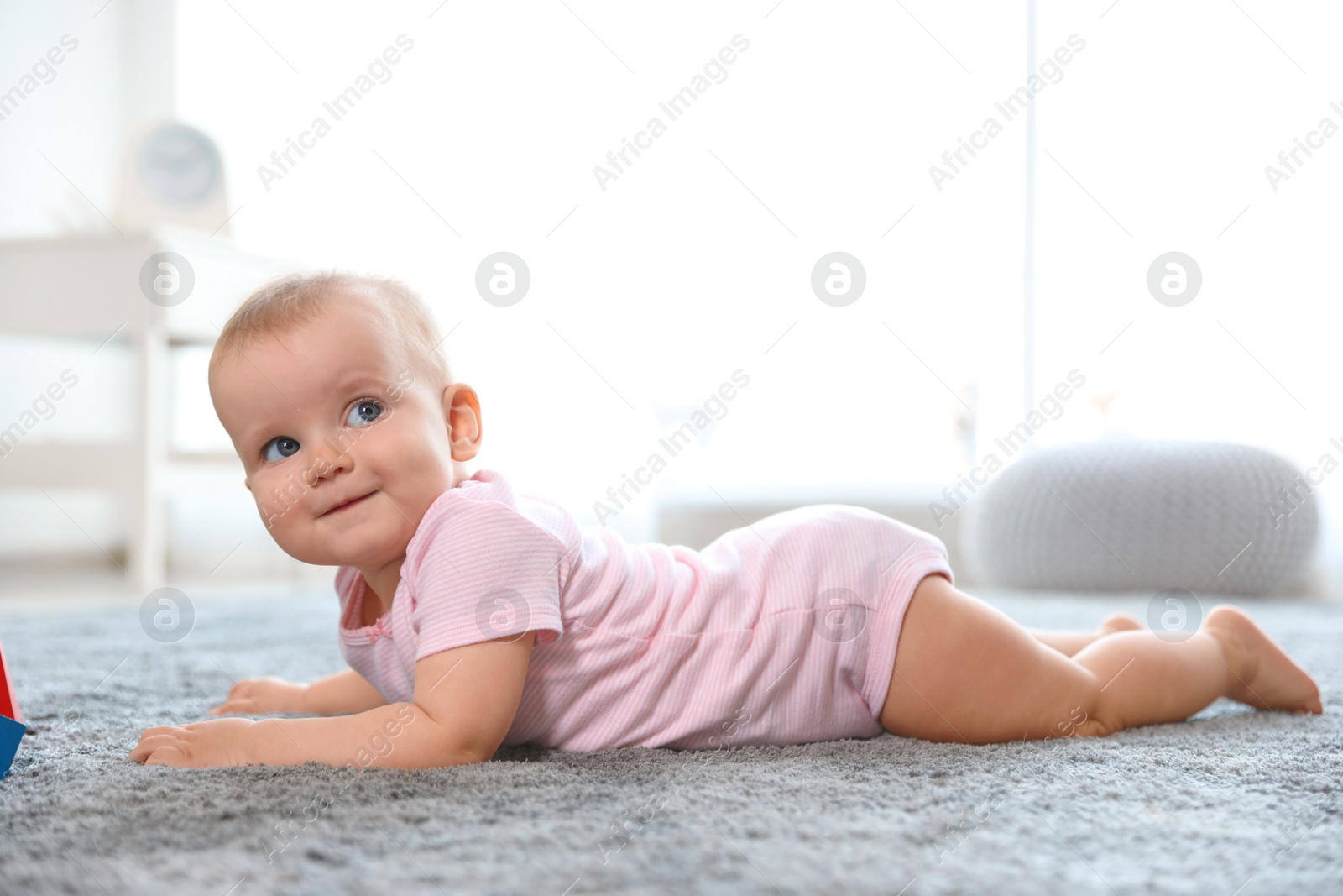 Photo of Cute baby girl lying on floor in room