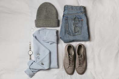 Photo of Stylish look with cashmere sweater, flat lay. Women's clothes and accessories on fabric