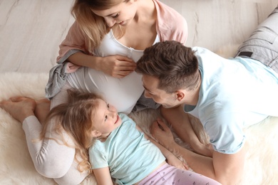 Young pregnant woman with her family at home