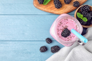 Photo of Flat lay composition with delicious blackberry smoothie on blue wooden background. Space for text