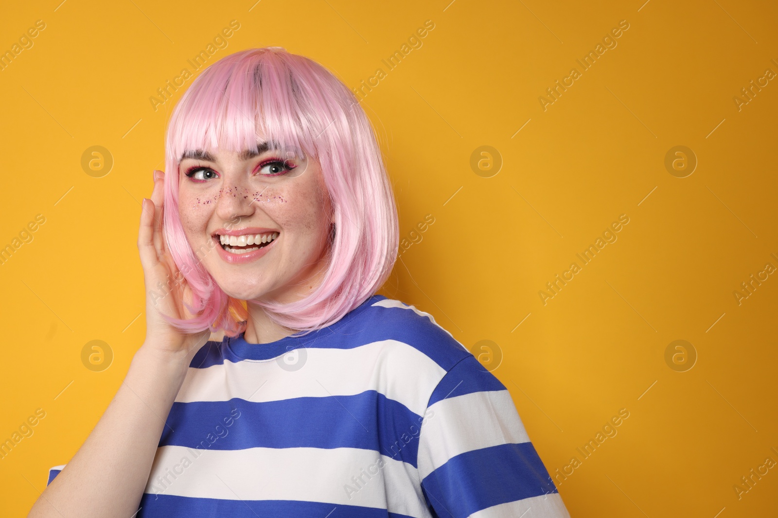 Photo of Happy woman with bright makeup and glitter freckles on yellow background. Space for text