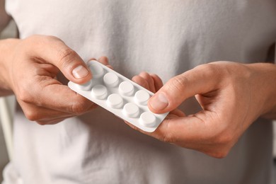 Photo of Man taking pill out from blister pack, closeup