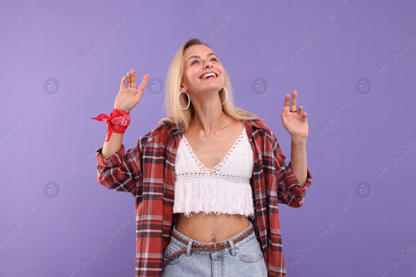 Photo of Portrait of happy hippie woman on purple background