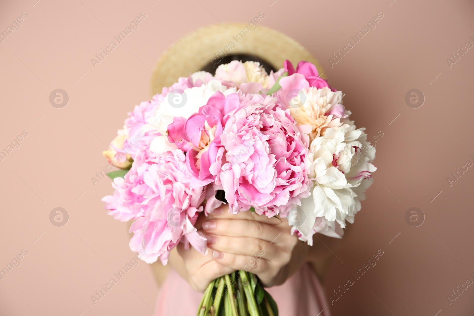 Photo of Woman with bouquet of beautiful peonies on beige background, closeup