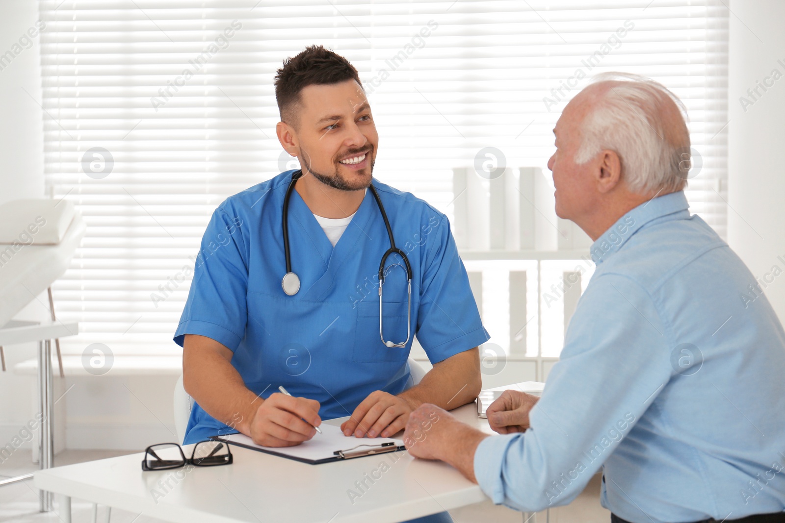 Photo of Doctor examining senior patient in modern office