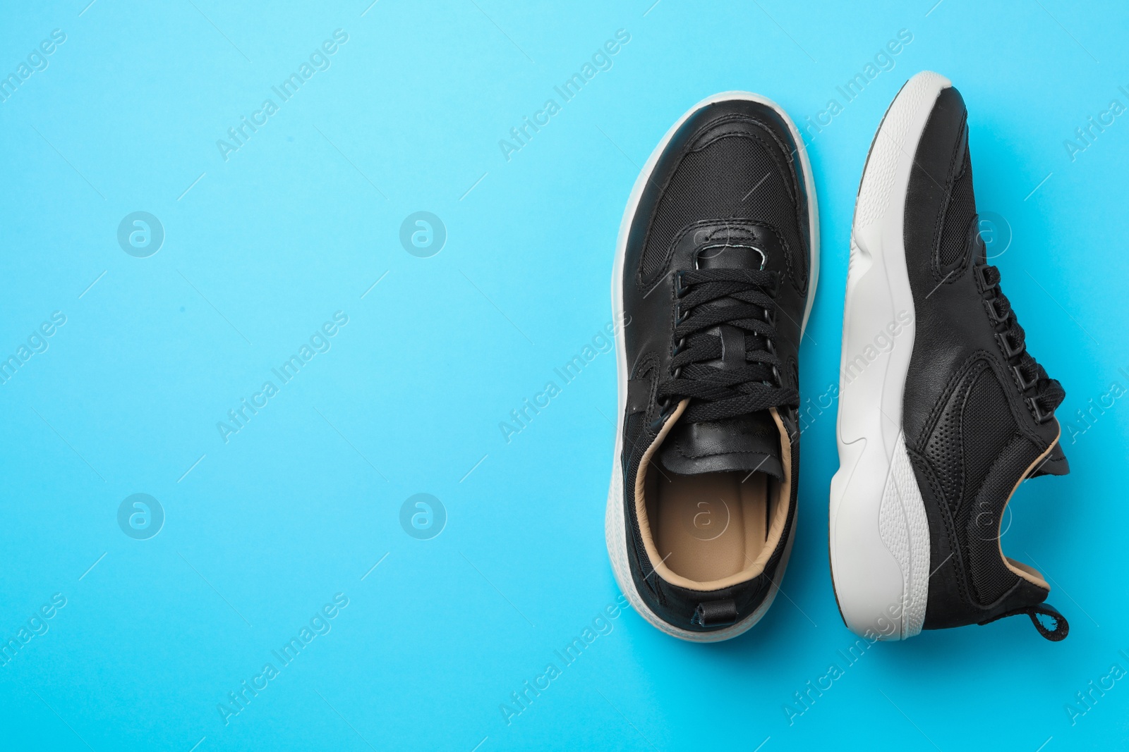 Photo of Pair of stylish shoes on blue background, top view. Space for text