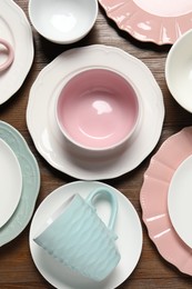 Photo of Beautiful ceramic dishware and cup on wooden table, flat lay