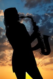 Silhouette of woman playing saxophone against beautiful sky at sunset