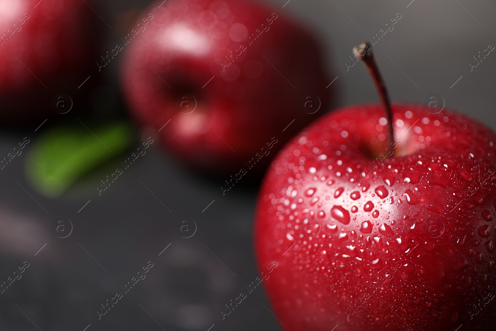 Photo of Fresh ripe red apples with water drops on table, closeup. Space for text