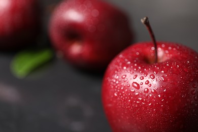 Photo of Fresh ripe red apples with water drops on table, closeup. Space for text