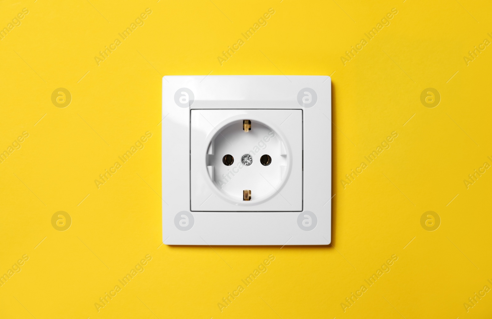 Photo of Power socket on yellow wall. Electrical supply