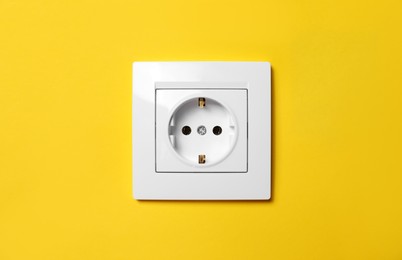 Power socket on yellow wall. Electrical supply