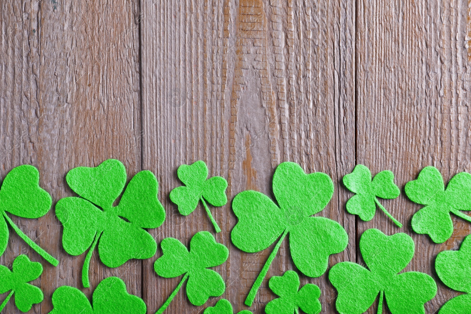 Photo of Flat lay composition with clover leaves on wooden table, space for text. St. Patrick's Day celebration