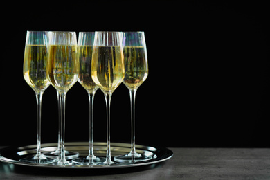 Photo of Glasses of champagne on grey table. Space for text