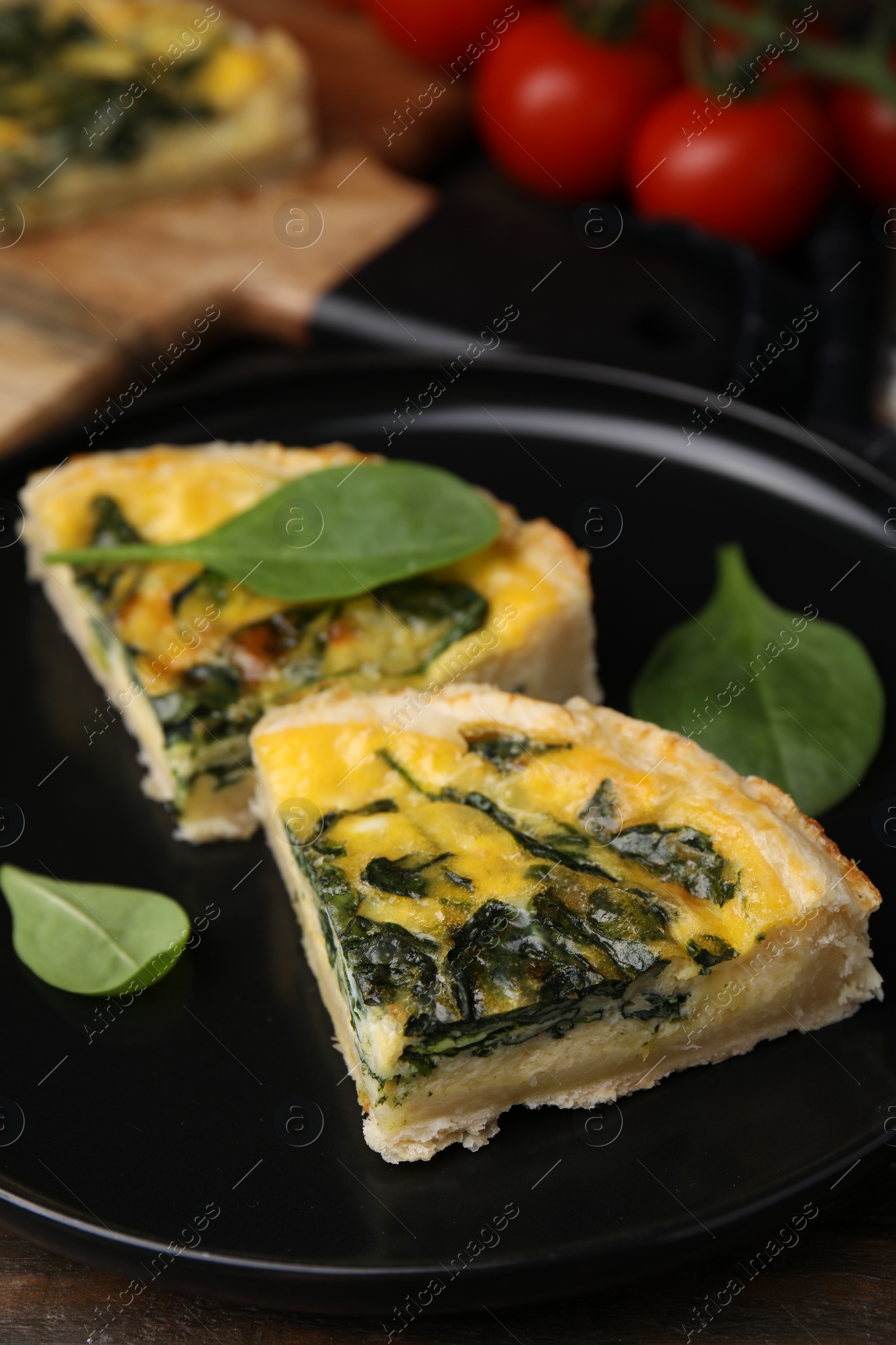 Photo of Pieces of delicious pie with spinach on table, closeup