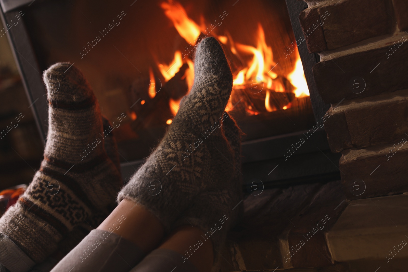 Photo of Couple resting near fireplace indoors, closeup. Winter vacation