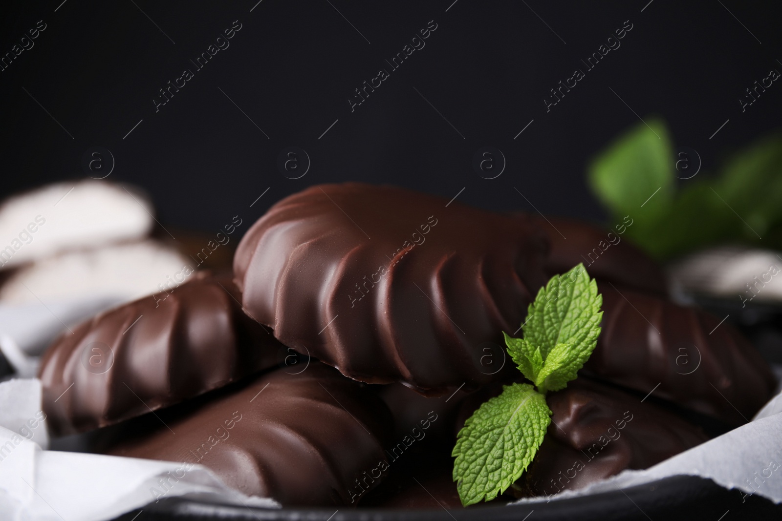 Photo of Delicious chocolate covered marshmallows with mint, closeup