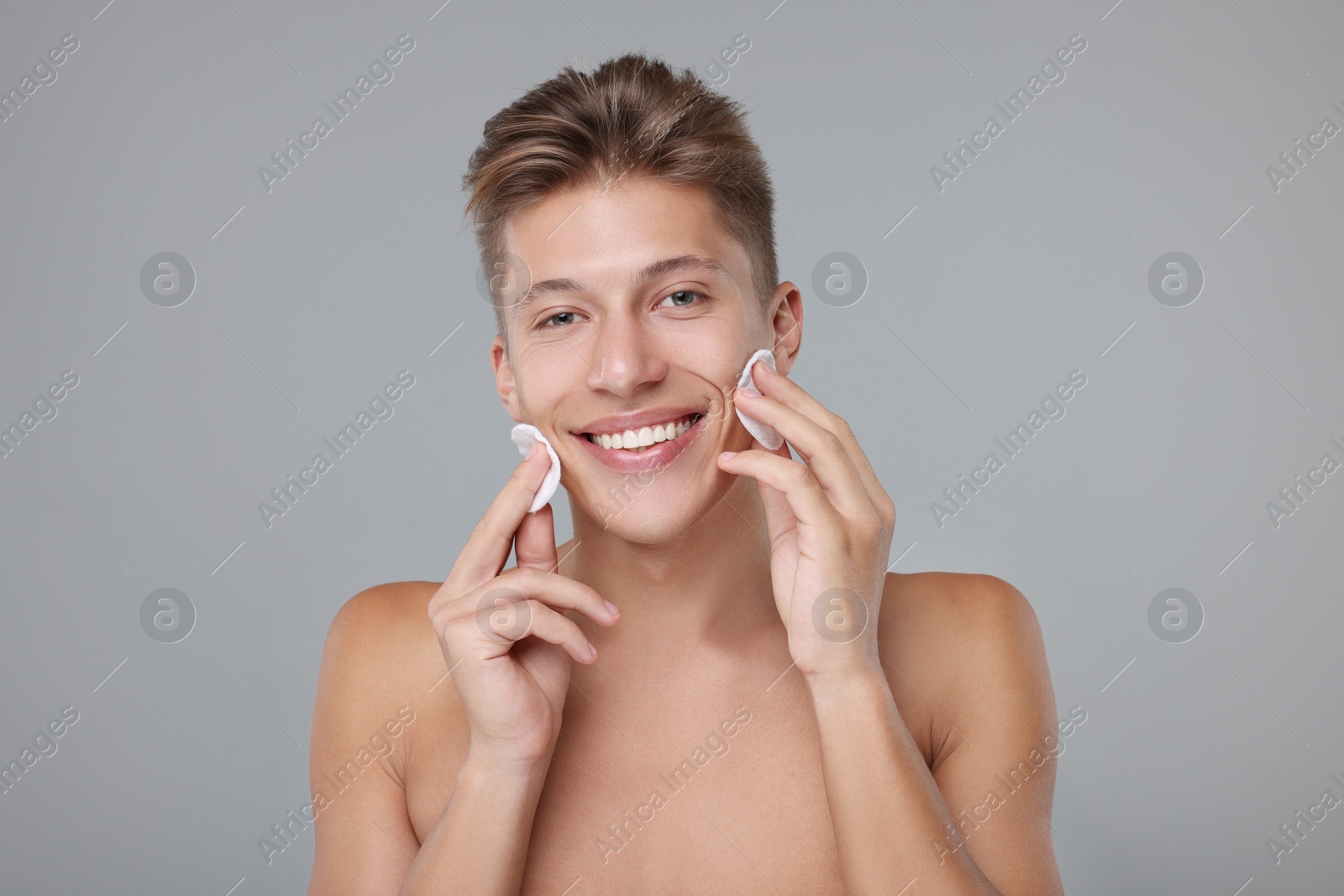 Photo of Handsome man with cotton pads on grey background