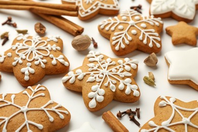 Tasty Christmas cookies with icing and spices on white background, closeup