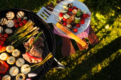 Photo of Cooked food products and grill barbecue outdoors, top view
