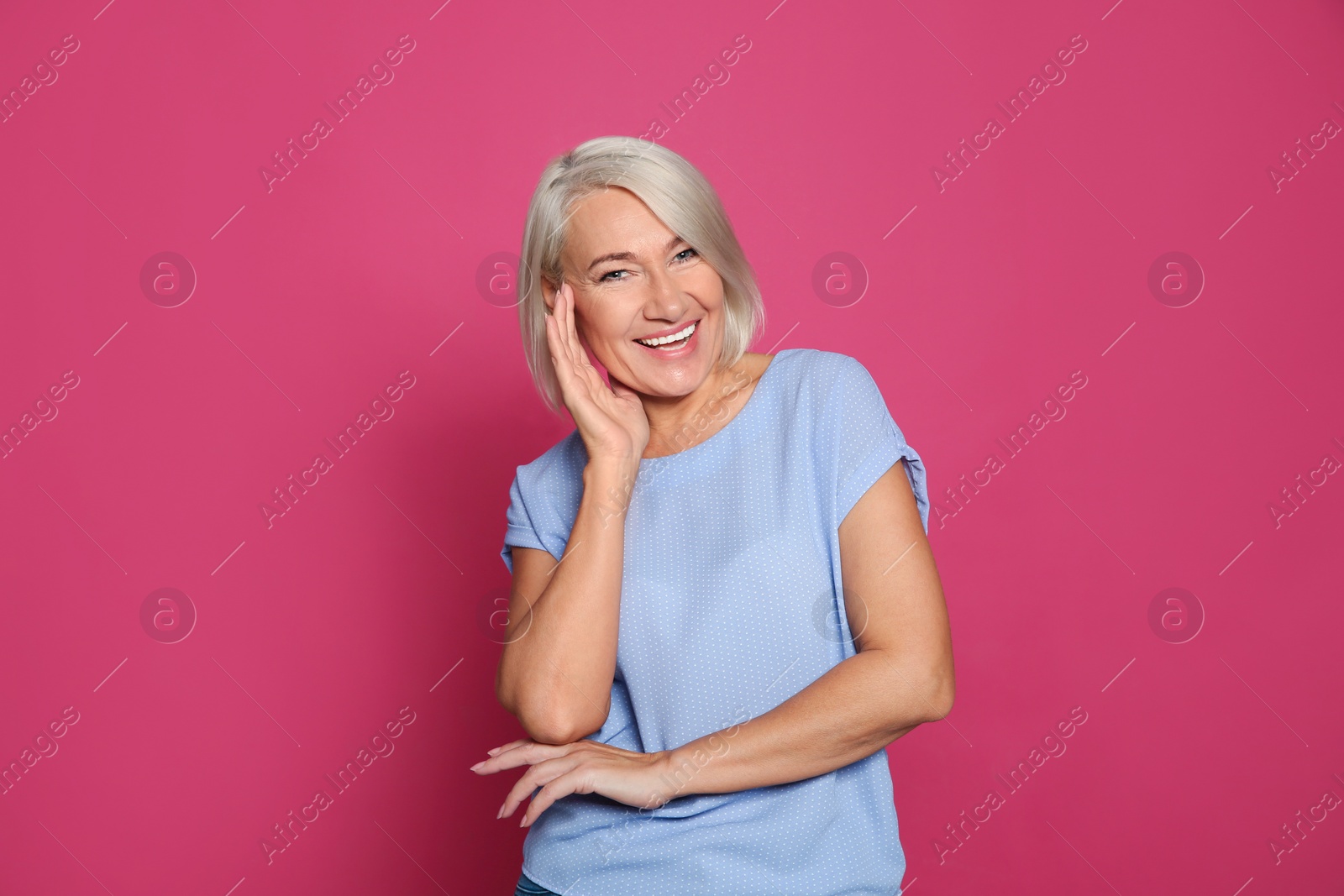 Photo of Portrait of mature woman laughing on color background