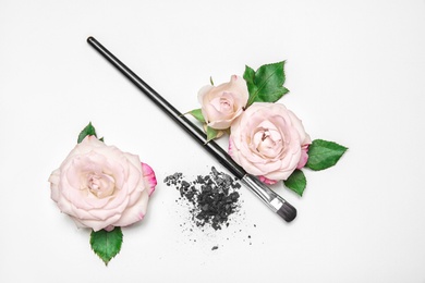 Photo of Flat lay composition with makeup brush and flowers on white background