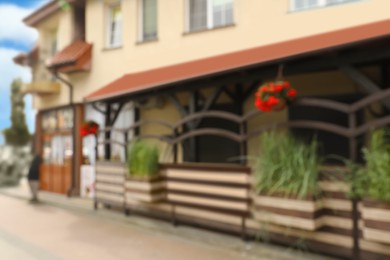 Photo of Blurred view of outdoor cafe decorated with beautiful plants