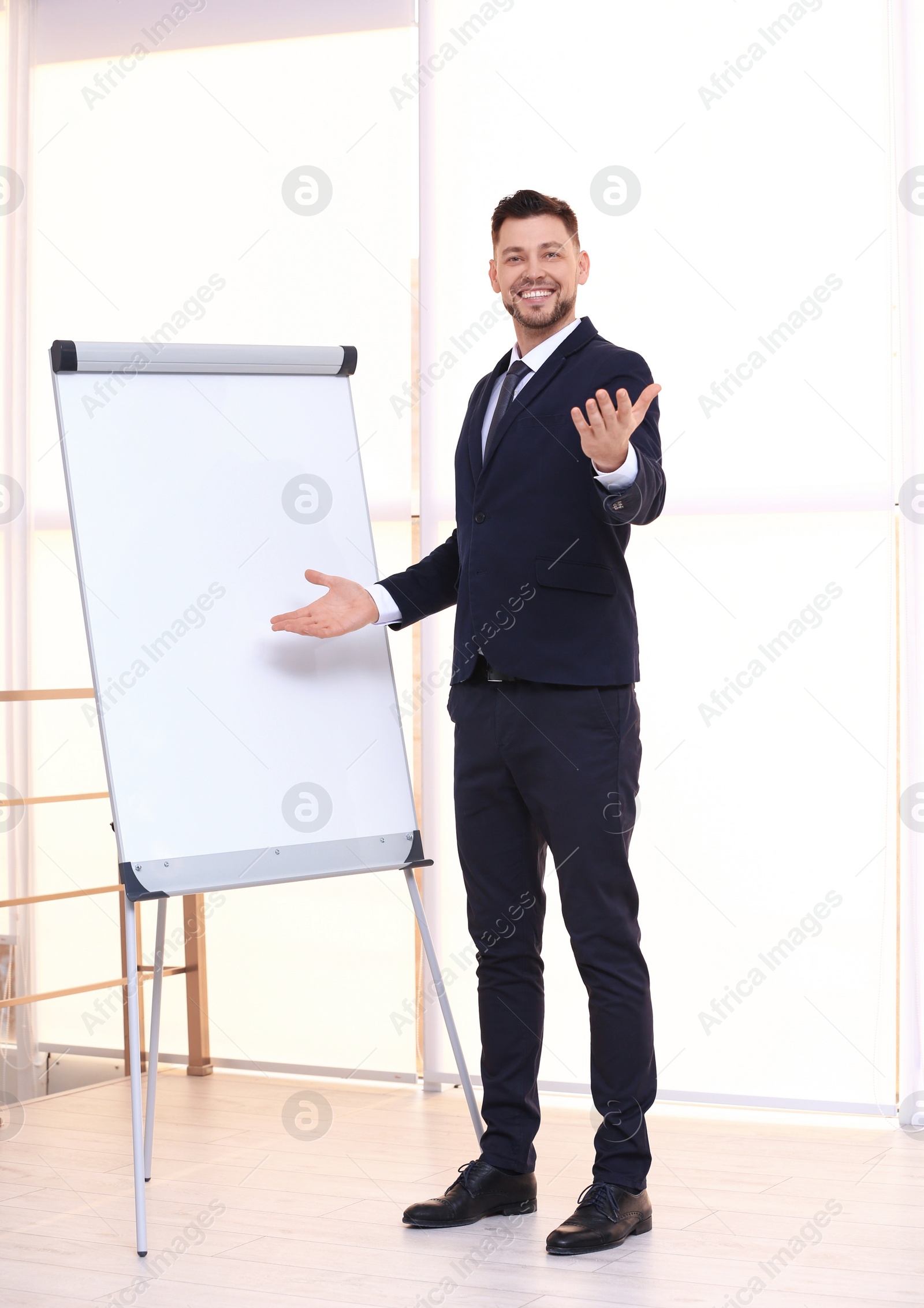 Photo of Young business trainer near flip chart, indoors