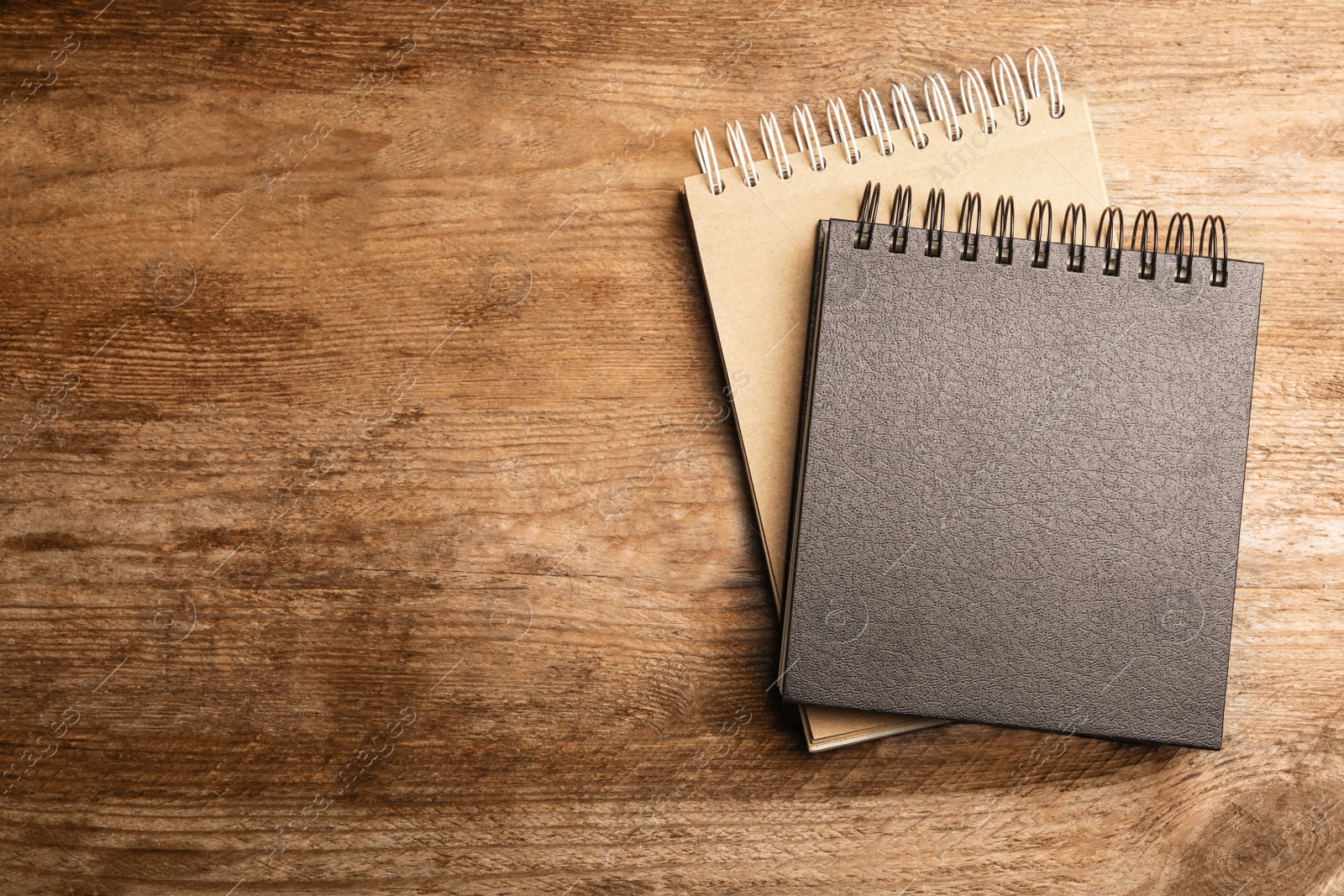 Photo of Stylish notebooks on wooden table, top view. Space for text