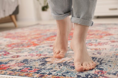 Photo of Woman standing on carpet with pattern in room, closeup. Space for text