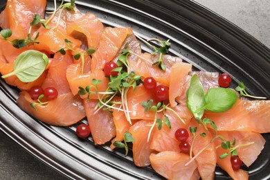 Photo of Delicious salmon carpaccio served on grey table, top view