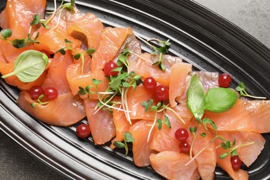 Delicious salmon carpaccio served on grey table, top view