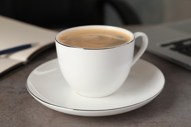 Cup of americano on grey table in office, closeup. Coffee Break