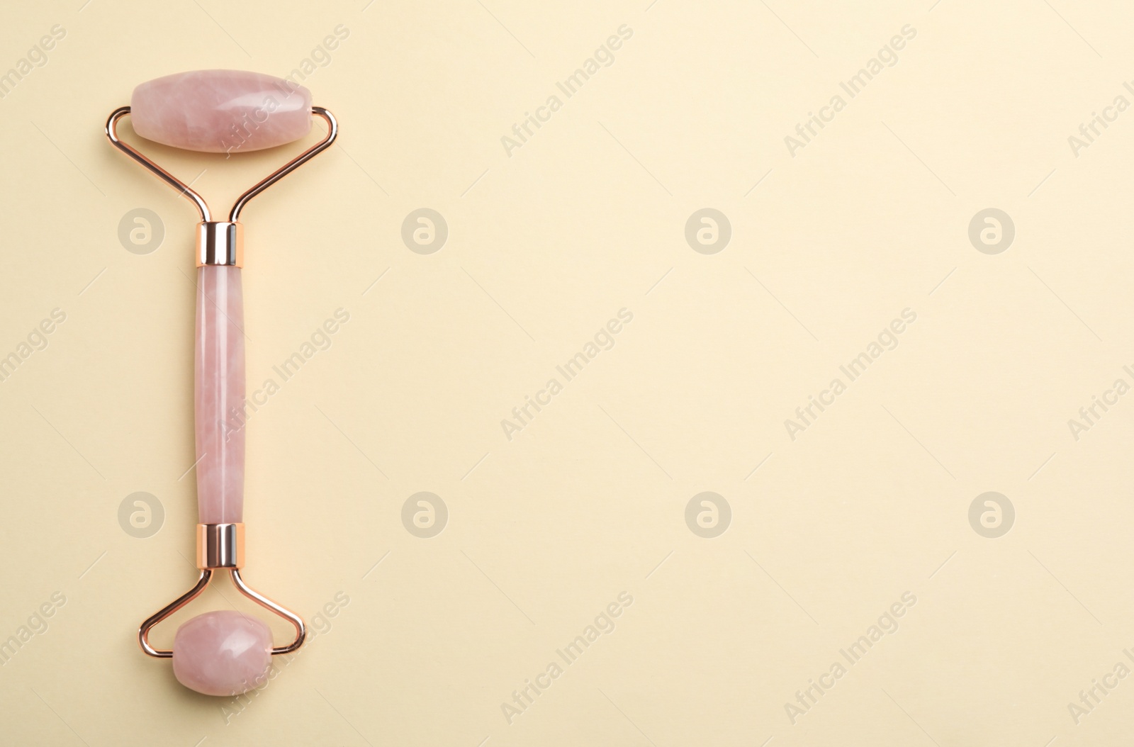 Photo of Natural face roller on beige background, top view. Space for text