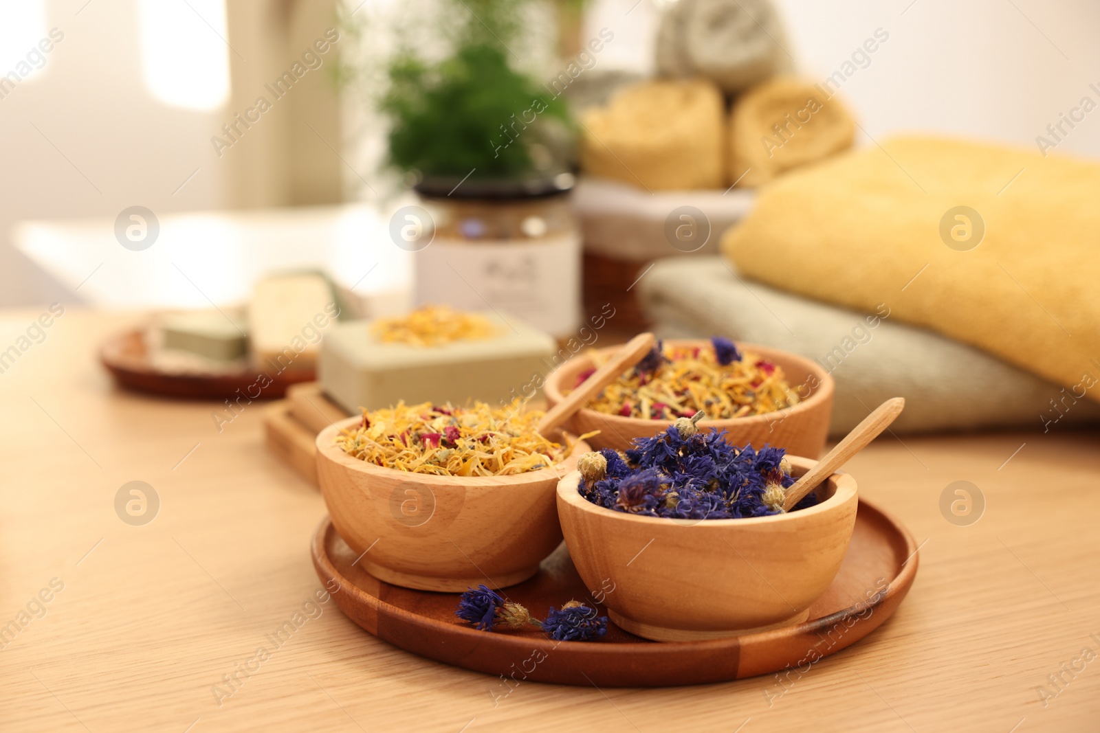 Photo of Dry flowers on wooden table indoors. Spa time