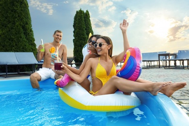 Group of happy people with refreshing drinks enjoying fun pool party